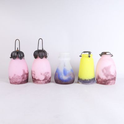 Plusieurs vases de différentes couleurs sont alignés sur une surface blanche