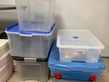 trois boîtes de rangement en plastique posées les unes à côté des autres sur le sol