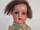 a small doll with a very long hair on it ' s head