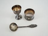 deux cuillères en argent et deux tasses en argent posées sur un plateau blanc