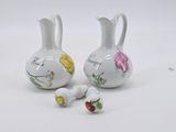 two vases with flowers painted on them on a white surface