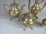 three silver teapots and a tea pot sitting on a table