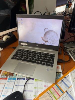 un ordinateur portable posé sur un bureau encombré