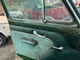 a green car with a door handle and a window