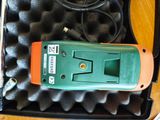 un outil vert et orange dans un étui posé sur une table