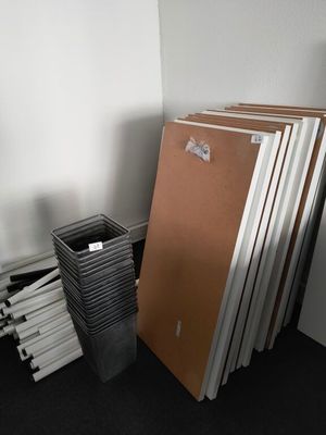 a stack of books sitting on the floor next to a trash can