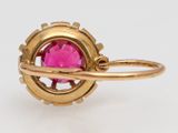 a close up of a gold ring with a pink stone in it