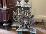 a silver clock sitting on a wooden floor next to a dresser