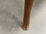 a close up of a wooden table with a wooden leg