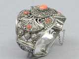 an image of a silver bracelet with an orange stone on it