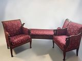 two red chairs and a bench in a room with a white wall