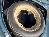 a tire in the trunk of a car with the hood open