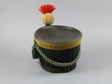 a small black drum with a red hat on top