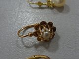 three pairs of gold and pearl earrings on a white surface
