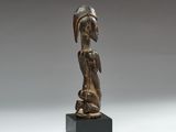 an image of a wooden statue of a woman with a bird on her head