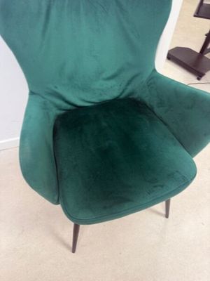 une chaise verte qui se trouve dans un coin de la pièce