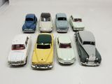 several toy cars are lined up in a row on a white surface