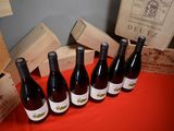 several bottles of wine are lined up on a red table