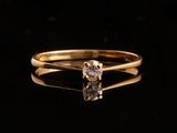 une bague en or sertie d'un seul diamant sur un fond noir
