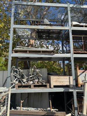 une cage à oiseaux avec un chat à l'intérieur, posée sur un tas de vieilleries