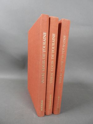 three books are stacked on top of each other on a gray surface