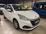 La petite voiture blanche est garée dans le garage, à côté d'autres voitures.