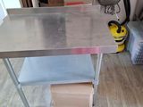 a stainless steel work table with a drawer underneath it