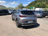 the rear end of a silver car parked in a parking lot