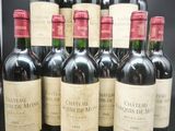six bouteilles de vin rouge sont alignées sur une table noire