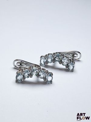 paire de boucles d'oreilles en argent ornées de cristaux bleus sur fond blanc