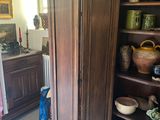 a tall wooden cabinet in the middle of a room