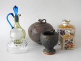 trois vases et une bouteille posés sur une surface blanche