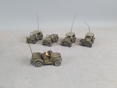 several toy army vehicles are lined up in a row on a white surface