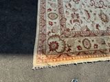 a rug on the ground with a pair of shoes next to it