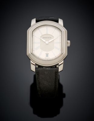 a close up of a watch on a black surface with a dark background