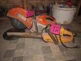 a chainsaw that is sitting on the floor next to a bucket