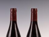 two bottles of wine sitting next to each other on a table