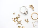 many different types of rings and earrings on a white surface