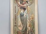 une vieille photo d'une femme en robe tenant une fleur
