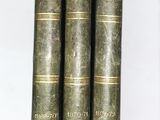 trois vieux livres sont empilés sur une table