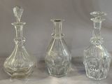 three clear glass bottles sitting next to each other on a table
