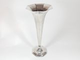 a silver vase that is sitting on a white surface