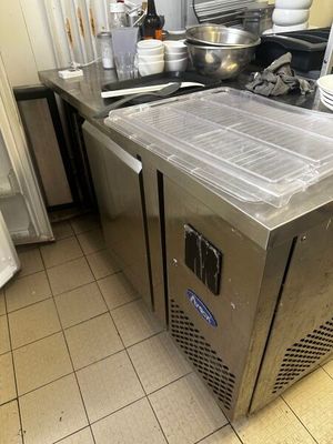 plan de travail en acier inoxydable dans une cuisine commerciale avec des casseroles et des poêles dessus