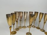 several gold colored wine glasses are lined up in a circle