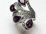 une image représentant une bague sertie de grenats sur un fond blanc