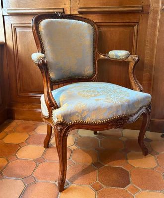 une chaise dont l'assise est recouverte d'un tissu bleu