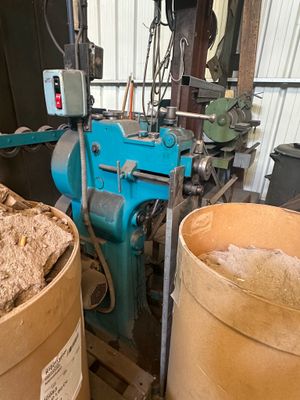 deux seaux remplis de bois à côté d'une machine bleue