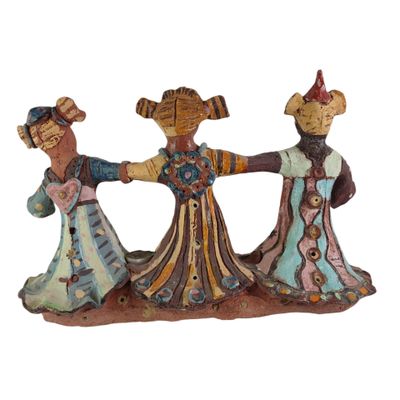 deux figurines représentant trois femmes se tenant par la main sur un fond blanc