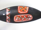 a black and orange boat shaped object on a white surface
