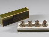 three silver salt and pepper shakers in a box with a box in the background